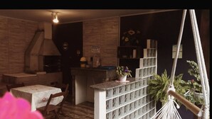 A cozy room with a dining area, a kitchen, and a hammock.