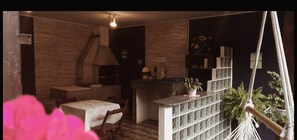 A cozy room with a dining area, a kitchen, and a hammock.