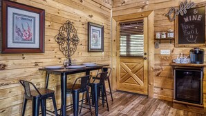 A rustic wooden interior with a wooden door, framed pictures, a chalkboard sign, and a coffee machine. - Douglas Lake Cabin Rental-Access to Boat Launch-Pool Table-Internet-Hot Tub (Sevierville)
