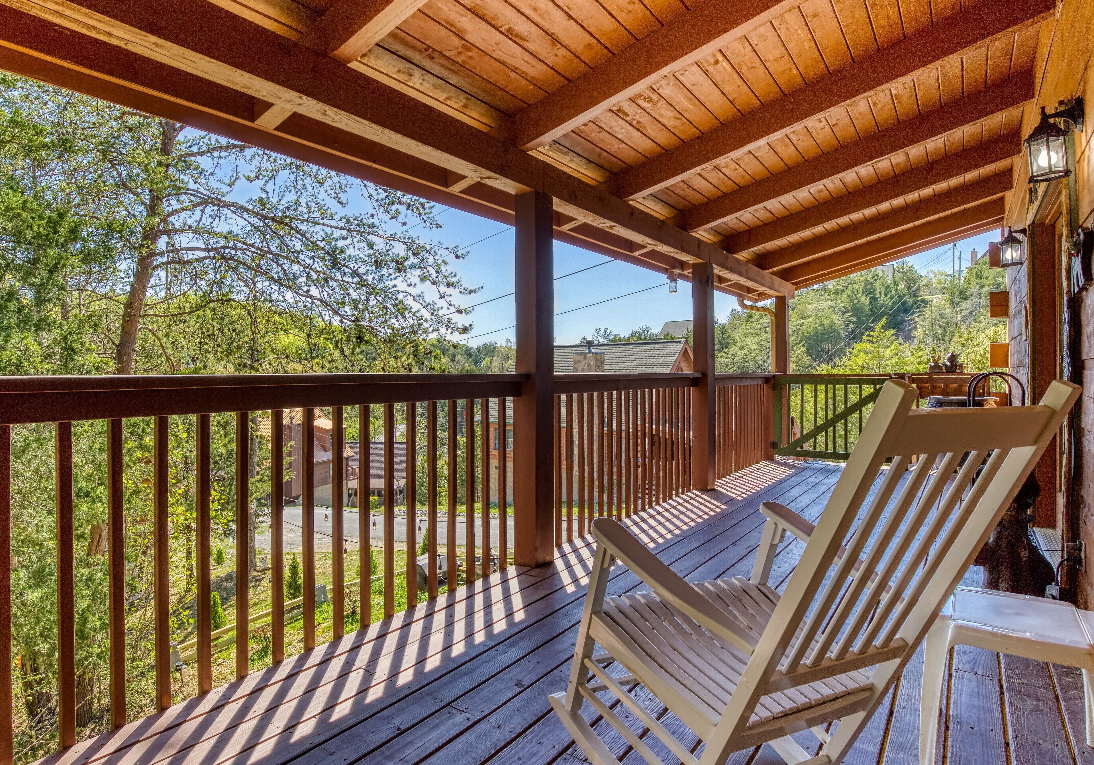 Une terrasse en bois avec une rambarde, un banc et une table.