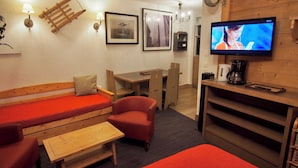 Una stanza accogliente con un letto, una scrivania, una sedia e una televisione.