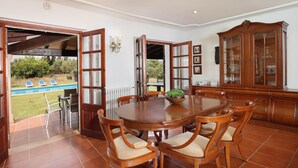 A dining area with a large wooden table, six chairs, and a cabinet. - COLLET VELL. Lovely stone-clad villa with large garden (Pollensa)