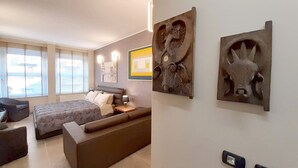 A modern bedroom with a bed, a sofa, and two wall-mounted sculptures. - Suite Central Station Milano (Milano)