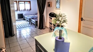 Una habitación con cama, escritorio, planta y puerta.