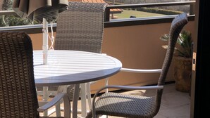 A balcony with a table and chairs, overlooking the ocean. - Destin, FL Spacious 3BR Condo,  Family Friendly  (Destin)