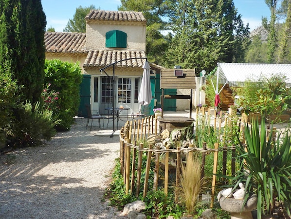 A rustic house with a gravel path, outdoor seating, and a garden with plants and a bird bath. - A little piece of paradise in the heart of the Alpilles, complete with a spa (Saint-Rémy-de-Provence)