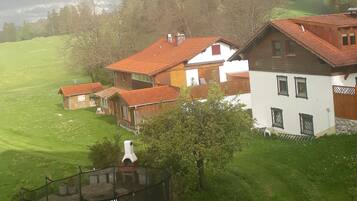 Ein Haus mit rotem Dach, einem Sprungtuch und einem grünen Rasen.