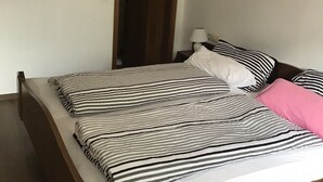 A bedroom with a bed, a nightstand, a lamp, and a door. - Quite double rooms with breakfast (Hornberg)