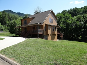 A two-story house with a covered porch and a stone foundation.
