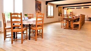 A dining area with wooden chairs and a table, large windows, and a painting on the wall. - Cozy home in Méjannes-le-Clap (Méjannes-le-Clap)
