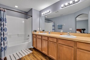 Een bad/douchecombinatie, een haardroger, handdoeken, zeep