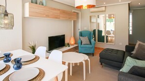 A modern living room with a TV, seating, and a dining area. - Stunning apartment in Santa Pola (Santa Pola)