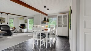 A spacious dining area with a white table and chairs, a stone-tiled floor, and a view of greenery outside. - Gorgeous home in Toftlund with WiFi (Toftlund)