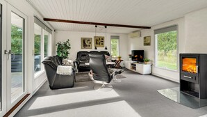 A modern living room with a fireplace, leather sofas, and large windows. - Gorgeous home in Toftlund with WiFi (Toftlund)