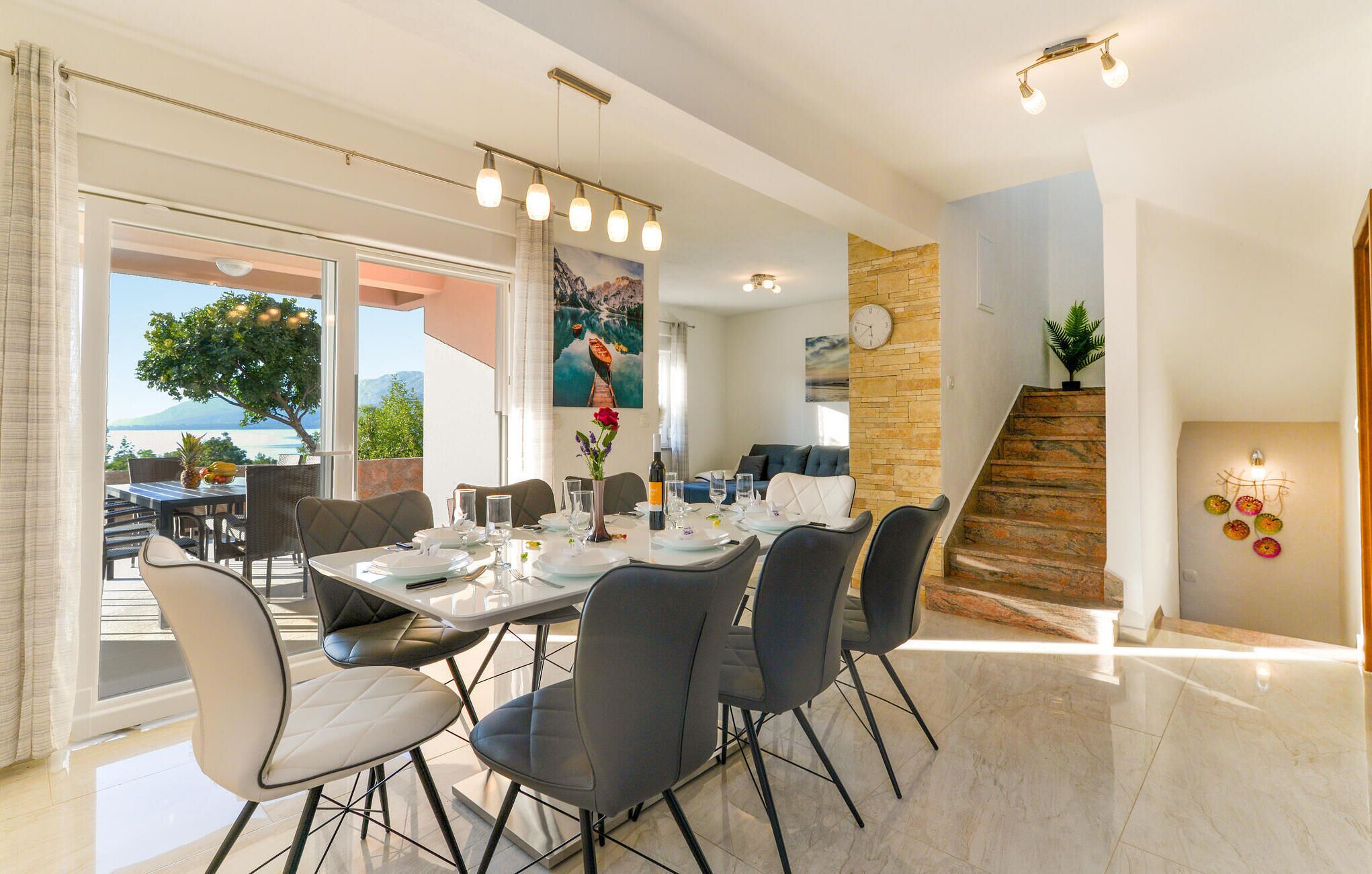 A dining area with a table set for four, chairs, and a view of the outdoors.