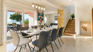 Un comedor con una mesa dispuesta para cuatro personas, sillas y vistas al exterior.