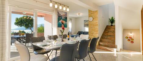 A dining area with a table set for four, chairs, and a view of the outdoors.