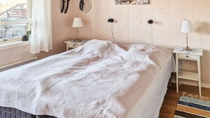 A bedroom with a bed, two bedside tables, a window with curtains, a wall-mounted mirror, and a framed picture. - 2 bedroom amazing home in åsensbruk (Åsensbruk)