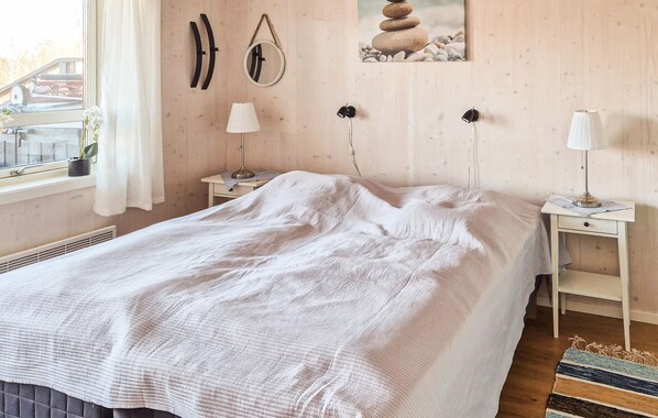 A bedroom with a bed, two bedside tables, a window with curtains, a wall-mounted mirror, and a framed picture. - 2 bedroom amazing home in åsensbruk (Åsensbruk)
