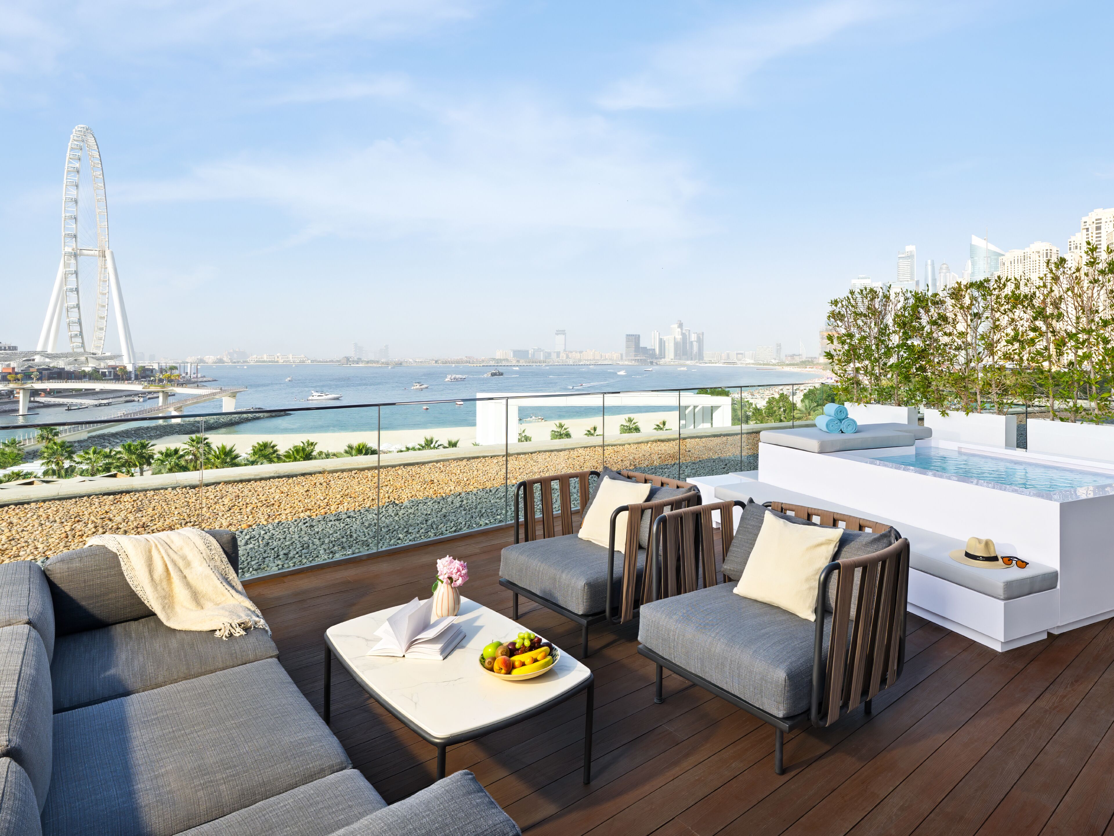 Terraza en la azotea con piscina, zona de estar y vistas del horizonte urbano y un puente.