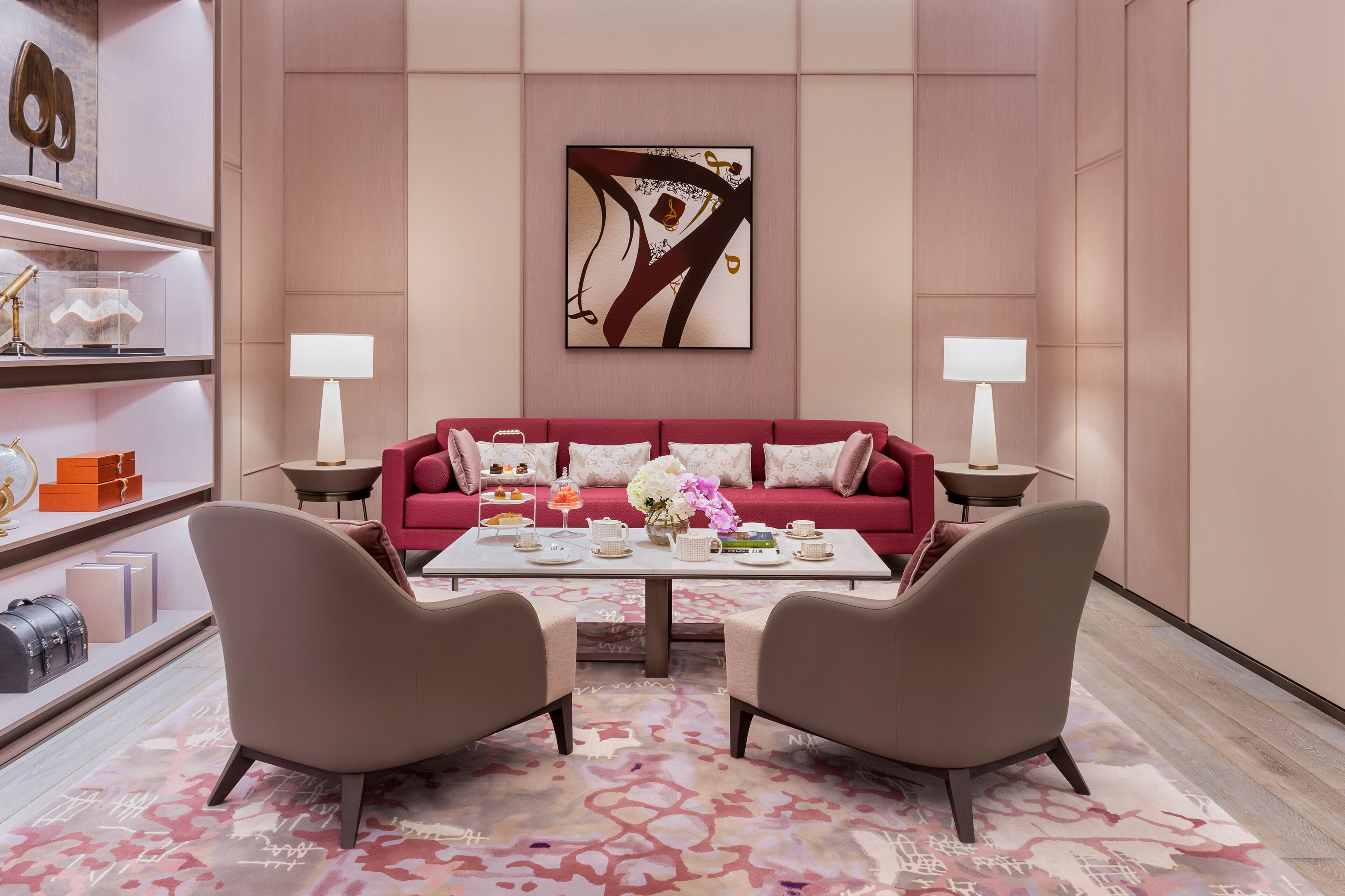 A modern living room with a red sofa, two armchairs, a coffee table, and decorative items.