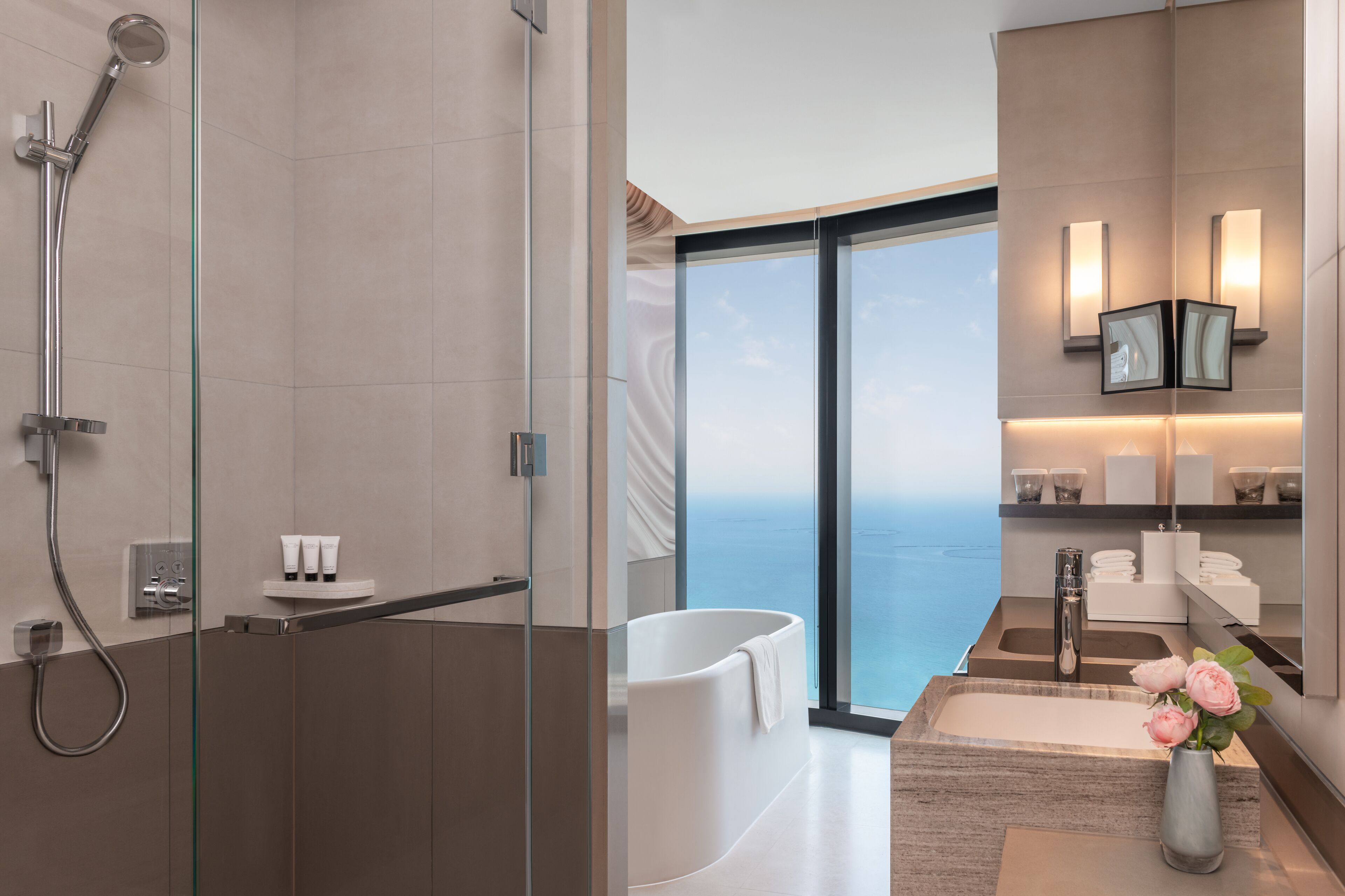 A modern bathroom with a glass-enclosed shower, a freestanding bathtub, and a vanity with a large mirror.