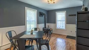 A room with a dining table, chairs, a heater, and a window. - *New* The Foundry Getaway 2BR / 1 BR (Saranac Lake)