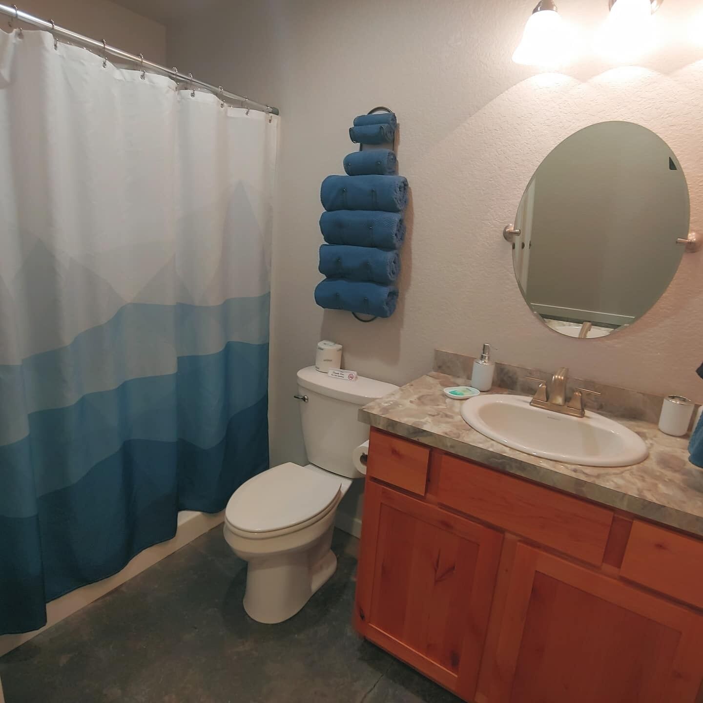 A bathroom with a toilet, sink, and mirror.