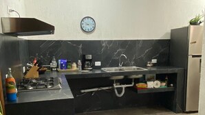 Une cuisine moderne équipée d’une cuisinière à gaz, d’un évier et d’appareils électroménagers en acier inoxydable.