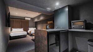 Een compacte hotelkamer met een bed, kitchenette, kleine badkamer en televisie.