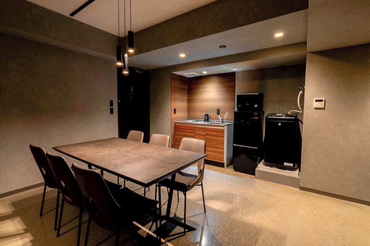 Una cocina moderna con encimera de madera, horno empotrado y refrigerador negro.