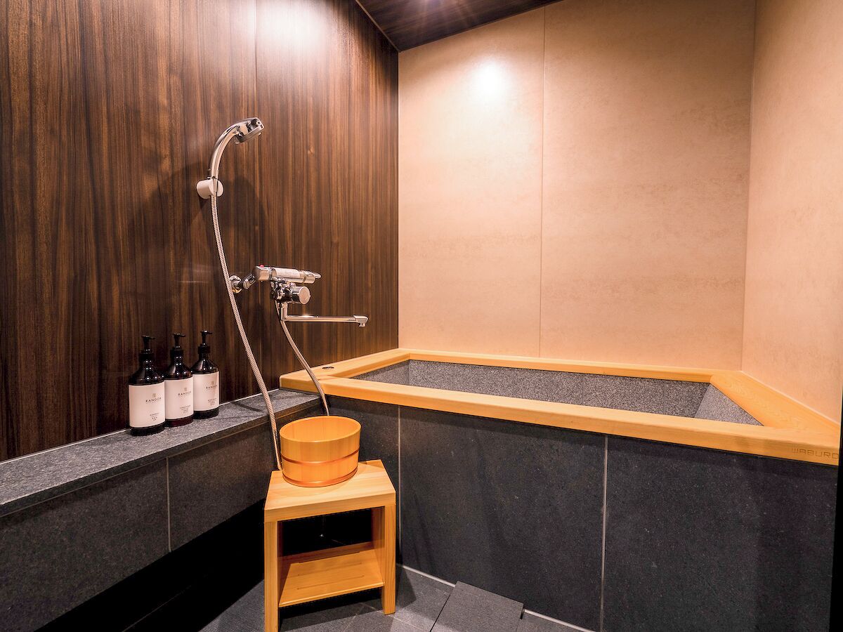 Une salle de bain moderne avec un meuble-lavabo en bois, une baignoire et un tabouret en bois.