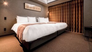 Een moderne hotelkamer met een groot bed, een inlijsting kunstwerk aan de muur en een raam met gordijnen.