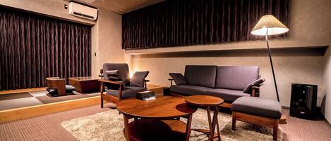A modern living room with a sofa, two armchairs, a coffee table, and a floor lamp.