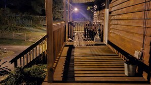 Un edificio de madera con un porche cubierto y una escalera que lleva a la entrada.