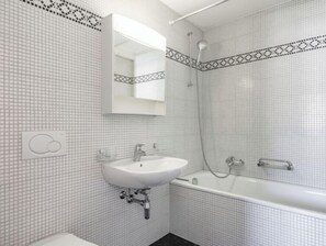 Ein Badezimmer mit Waschbecken, Spiegel, Dusche und Badewanne.