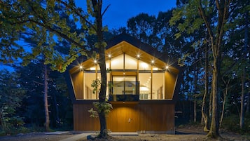 Escape to a secluded cabin nestled among mature trees, blending seamlessly into the forest surroundings.