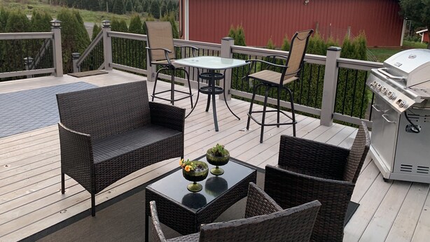 A deck with outdoor furniture, a grill, and a red barn in the background. - Wounded Knee Ranch at the Red Hills. Full separate and private suite with deck (Newberg)