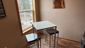 A small room with a window, a white table, two chairs, and a wooden wall decoration. - Wounded Knee Ranch at the Red Hills. Full separate and private suite with deck (Newberg)