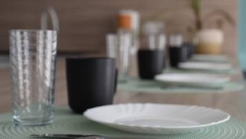 A dining table with plates, cutlery, and glasses set for a meal.