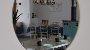 Un comedor con una mesa redonda, sillas y una lámpara colgante.