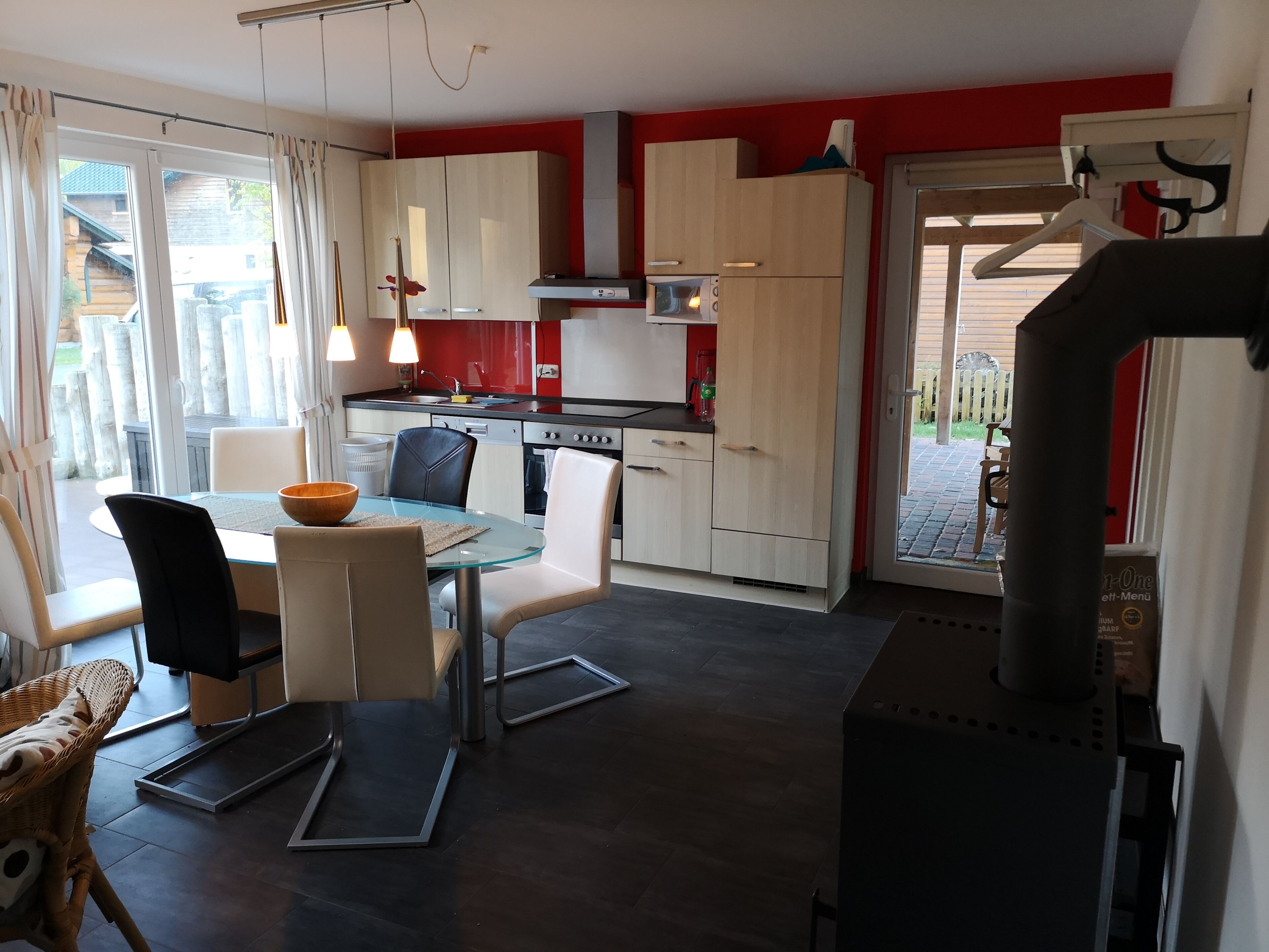 Et moderne køkken med spiseplads, der inkluderer en komfur, skabe og et spisebord med stole.