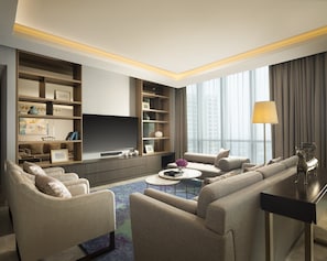 A modern living room with a sofa set, a coffee table, and a TV mounted on a wooden wall. - Intercontinental Residence Pondok Indah by IHG (Jakarta)