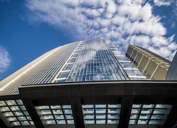 A high-rise building with a modern glass facade and a clear sky with clouds. - Intercontinental Residence Pondok Indah by IHG (Jakarta)