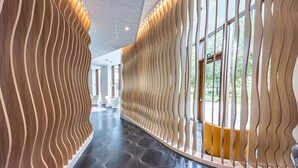 A modern hallway with wavy wooden panels and patterned flooring. - Prize by Radisson, Antwerp City (Antwerp)