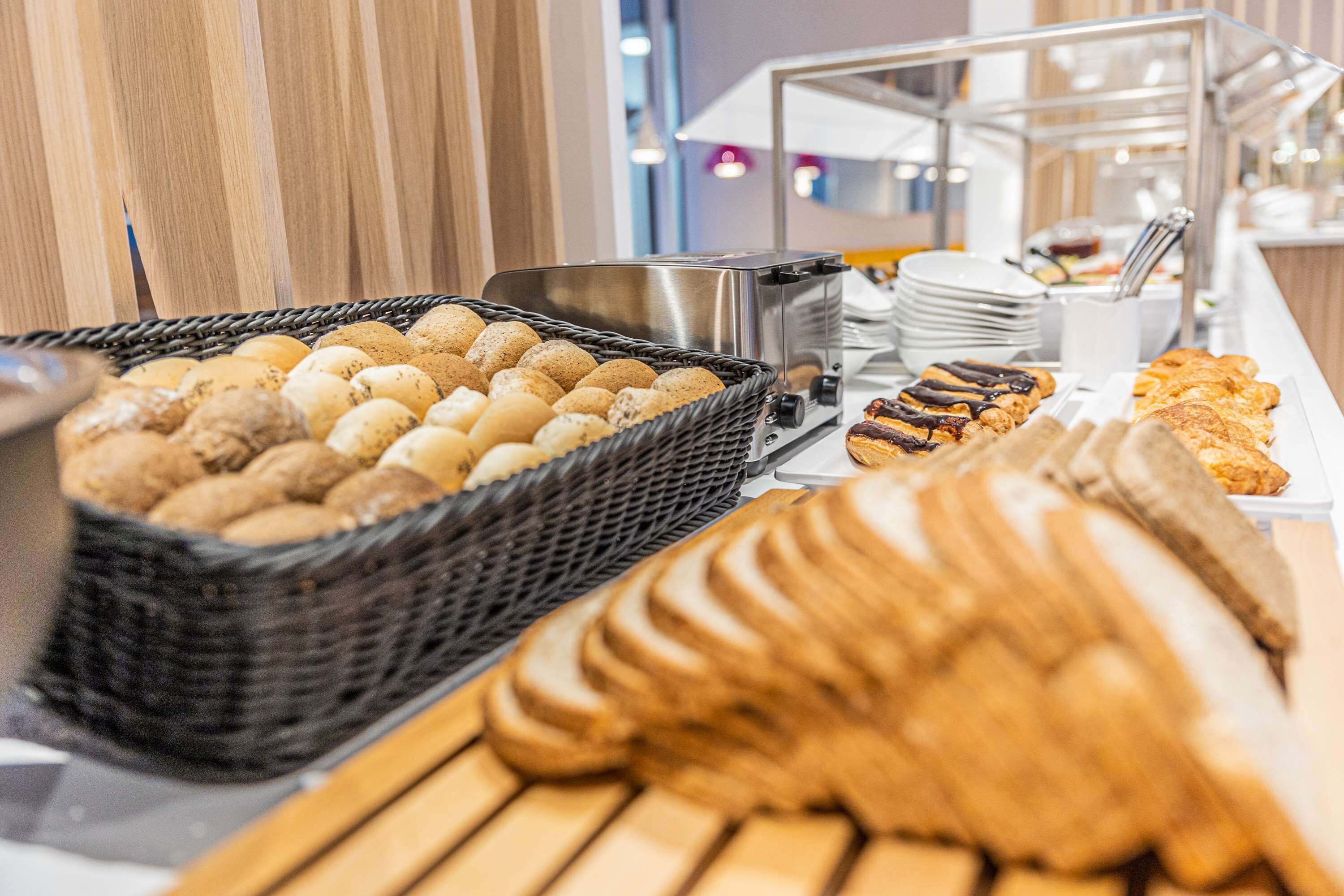 A buffet with various baked goods including bread, pastries, and cookies.
