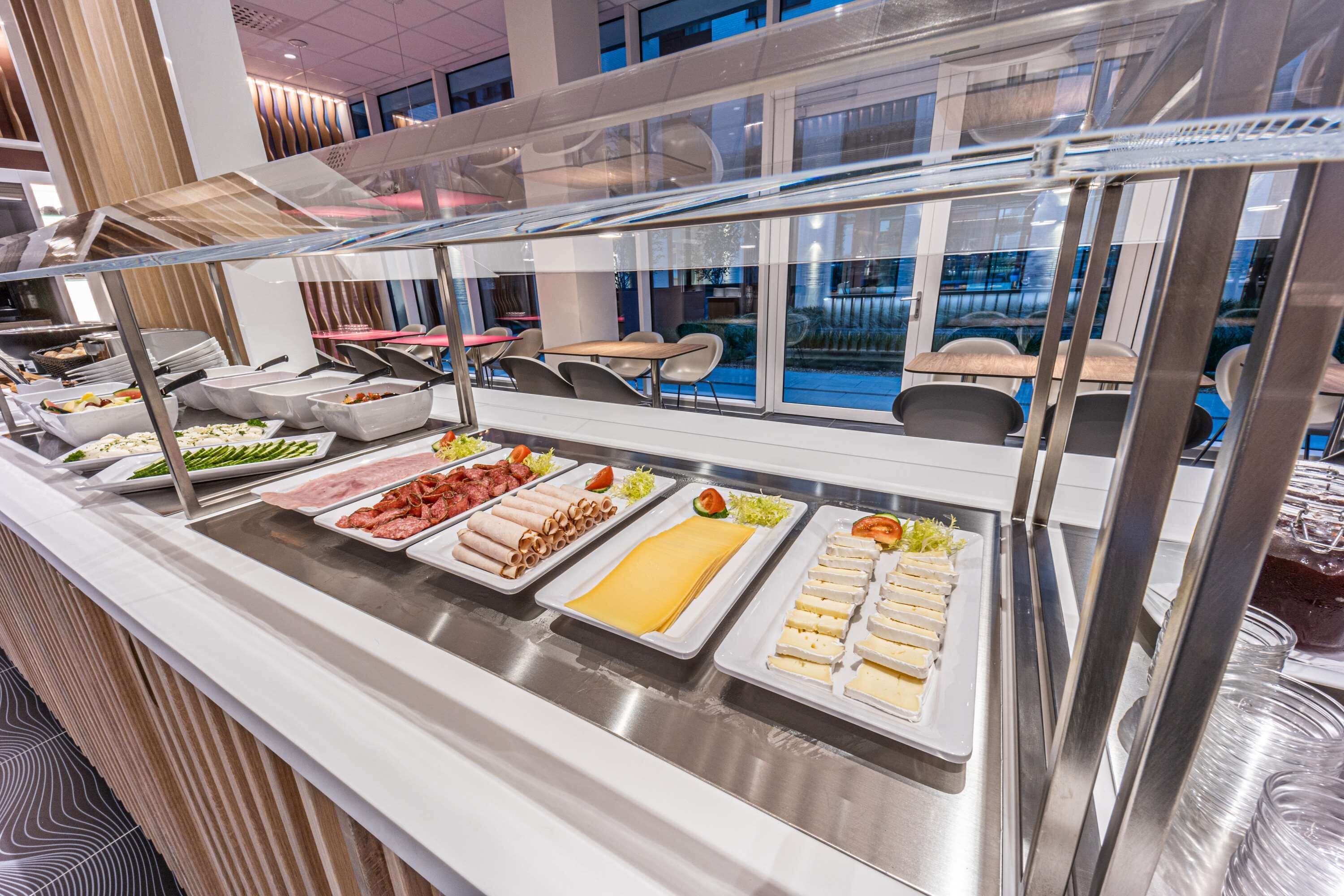A buffet with various food items including meats, cheeses, and salads.