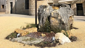A stone building with a turret and multiple windows. - Les Gîtes de l'Ermitage (Terce)
