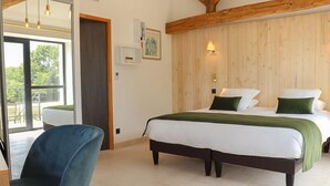 A bedroom with a bed, a chair, and a wooden ceiling. - Les Gîtes de l'Ermitage (Terce)