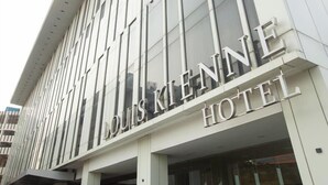 L’extérieur de l’hôtel Louis Klenne, avec sa façade moderne et ses grandes fenêtres.